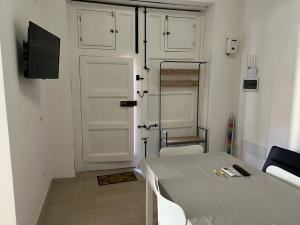 a room with a bed and a door and a tv at Casa del papà in Noto