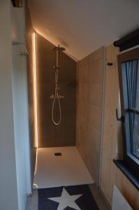 a bathroom with a shower with a hanger at La clef des bois in Paliseul