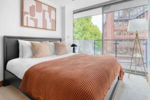 a bedroom with a bed and a large window at Exquisite 2 Bed Soho Central Apartment Sleeps 6 in London