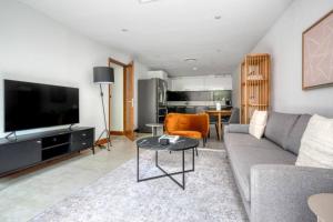 a living room with a couch and a tv and a table at Exquisite 2 Bed Soho Central Apartment Sleeps 6 in London
