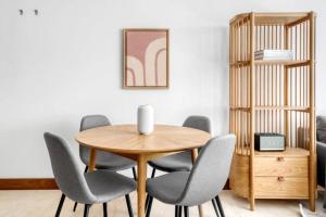 a dining room with a wooden table and chairs at Exquisite 2 Bed Soho Central Apartment Sleeps 6 in London