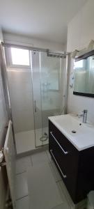 uma casa de banho com um chuveiro e um lavatório. em Appartement Meylan em Meylan