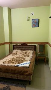 a bedroom with a bed and a chair in it at CITRUS Guest House in Yerevan