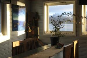 a dining room with a table and two windows at 3ART recreation in Tromsø