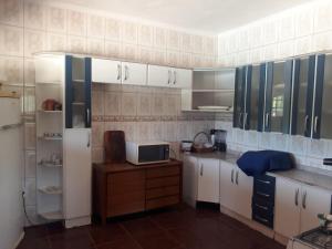 La cuisine est équipée de placards blancs et d'un réfrigérateur blanc. dans l'établissement Sitio para lazer, à Bragança Paulista