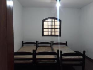 - une chambre avec 2 lits dans une chambre avec une fenêtre dans l'établissement Sitio para lazer, à Bragança Paulista