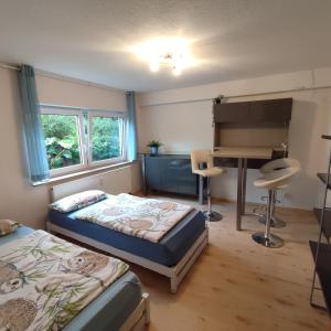 a bedroom with two beds and a desk in it at Siebeneichen in Affalterbach