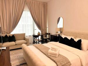 Classy Studio in Masdar City في Al Qurayyah: غرفة نوم بسرير كبير وغرفة معيشة