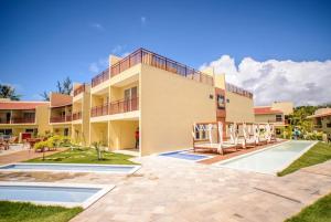 a large building with a swimming pool in front of it at Solar Flats - WooD - Pipa RN in Pipa