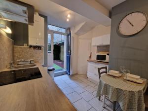 a kitchen with a table and a clock on the wall at Centre Historique LAVAL in Laval