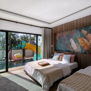 1 dormitorio con 2 camas y sala de juegos con tobogán. en Sichon Pool Villa - สิชลพูลวิลล่า 