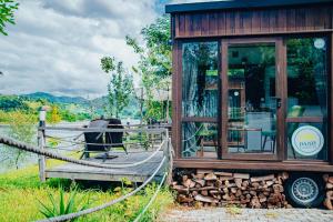 Cabaña de madera pequeña con terraza y silla en Danzi camping tiny house en Rize