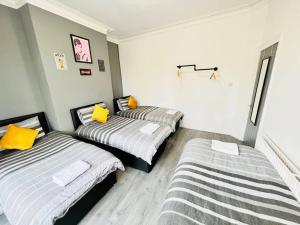 Cette chambre comprend 2 lits avec des oreillers jaunes. dans l'établissement NEW Spacious 8 Bedroom House Perfect For Groups, Hen, Stag, Football & More!, à Liverpool