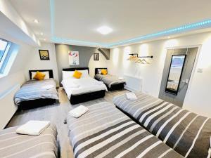 - un salon avec trois lits et un canapé dans l'établissement NEW Spacious 8 Bedroom House Perfect For Groups, Hen, Stag, Football & More!, à Liverpool