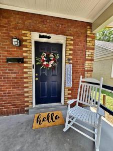 a blue door with a hello sign next to a bench at Cool and calm place to live in Memphis