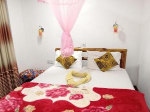 a bedroom with a bed with a red and white blanket at Bird Nest Inn in Ella