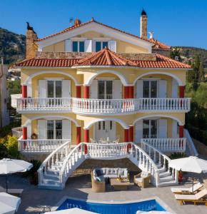 uma grande casa amarela com uma varanda e uma piscina em Villa Bella Sole em Kalipádhon
