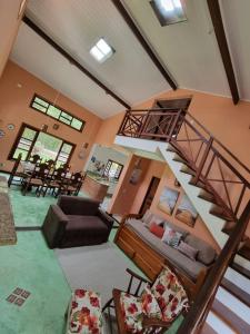 ein Wohnzimmer mit Wendeltreppe und Couch in der Unterkunft Casa praia de camburi in São Sebastião