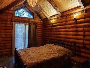 a bedroom with a bed in a log cabin at Getahovit Resort in Ijevan