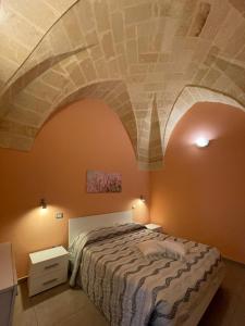 Schlafzimmer mit einem Bett mit Steindecke in der Unterkunft Il Rifugio in Oria