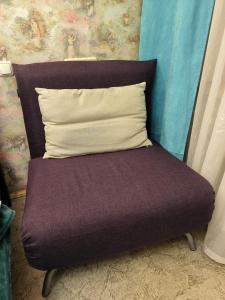 a purple chair with a pillow and a wall at 2-к квартира Малиновського 12. Набережна лівого берега. in Dnipro