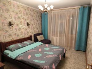 a bedroom with a bed and a chandelier at 2-к квартира Малиновського 12. Набережна лівого берега. in Dnipro