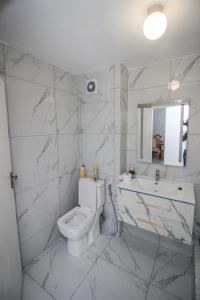a white bathroom with a toilet and a sink at NTVT @ Penzance in Durban