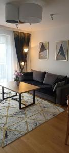NOVA Apartment في سانوك: غرفة معيشة مع أريكة وطاولة قهوة