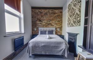 een slaapkamer met een bed en een bakstenen muur bij #1 Dunkirk by DerBnB, Modern 1 Bedroom City Centre Apartment, Free Parking, WI-FI, Netflix & Within Walking Distance of the City Centre in Derby