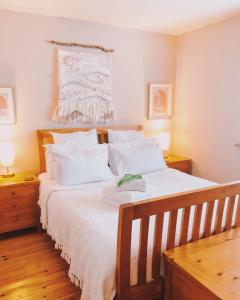 1 dormitorio con 1 cama grande con sábanas y almohadas blancas en Bantham Beach Pad, en Thurlestone
