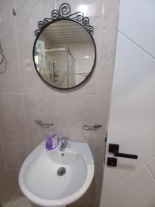 y baño con lavabo blanco y espejo. en Perovic 23, en Rafailovici