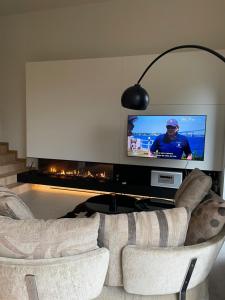 a living room with two chairs and a tv at Le Castel Mosan in Namur +85 photos