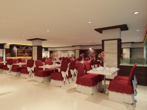 ein Esszimmer mit roten Stühlen und Tischen in einem Restaurant in der Unterkunft Hallmark Regency Hotel - Johor Bahru in Johor Bahru