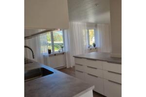 a kitchen with white cabinets and a sink in it at Stuga i Kristdala Oskarshamnsvägen 39 in Kristdala