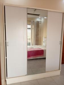Una puerta corredera de cristal en un dormitorio con cama en Kigali Peace villa, en Kigali