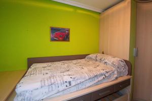 una camera con un letto con una parete verde di Casa Manuel ad Alcañiz