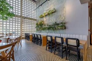 un restaurante con mesas y sillas y un cartel en la pared en Bondo Estudio, en Cartagena de Indias