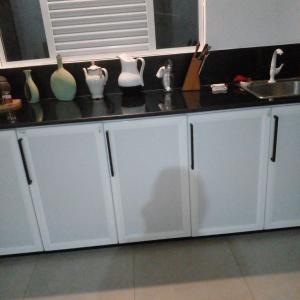 - un comptoir de cuisine avec des placards blancs et un évier dans l'établissement Kandyan Guest house, à Kandy