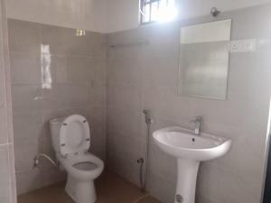 La salle de bains est pourvue de toilettes et d'un lavabo. dans l'établissement Kandyan Guest house, à Kandy