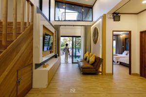 een woonkamer met een bank en een tv bij สิชลพูลวิลล่า -Sichon Pool Villa 