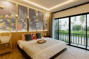 a bedroom with a large bed and a large window at สิชลพูลวิลล่า -Sichon Pool Villa 