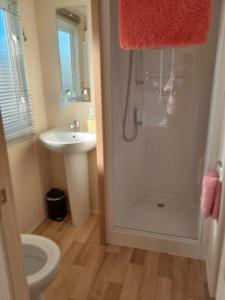 een badkamer met een douche, een toilet en een wastafel bij hollies retreat in Lossiemouth