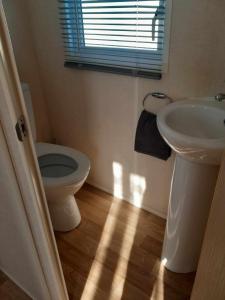 baño con lavabo y aseo y ventana en hollies retreat en Lossiemouth