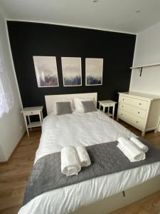 sypialnia z dużym białym łóżkiem i 2 ręcznikami w obiekcie Apartament w samym centrum! w mieście Dąbrowa Górnicza