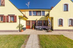 Casa amarilla con patio y sombrilla en Penzión Arkádia, en Kyselica