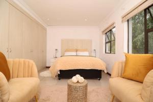 een slaapkamer met een bed en twee banken bij Smartz Luxury Home in Centurion