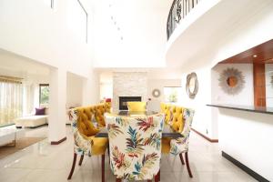 uma sala de jantar com uma mesa e cadeiras amarelas em Smartz Luxury Home em Centurion
