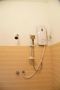 a shower in a bathroom with a hair dryer on the wall at The Tree House in Hikkaduwa