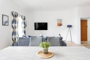 een woonkamer met een bank en een tafel bij Top Floor, City Centre, Parking in Belfast