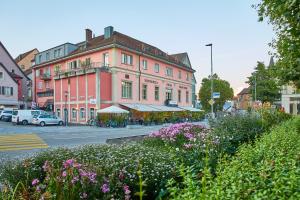 un edificio al lado de una calle con flores en Hotel Rotes Haus, en Brugg